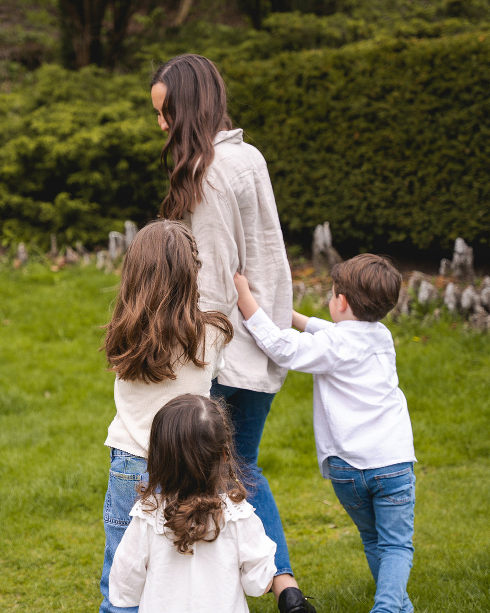 Rikki, founder of Smoovees, walking in a garden with her three children